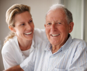 Closeup of a happy old man on the wheel chair with a nurse